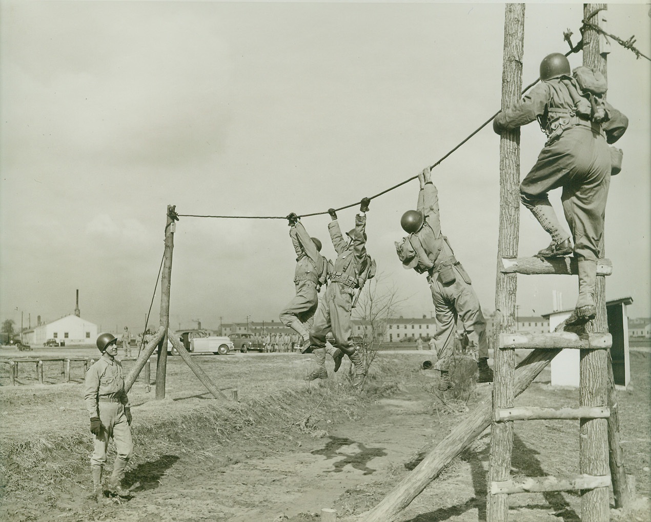 Union Leaders Get Taste of Army Life, 3/22/1943. Camp Atterbury, Ind.—Some of the 250 CIO-UAW leaders who are spending a few days at Camp Atterbury, Ind., to learn how our fighters live are shown above crossing over a hand-over-hand bridge, carrying full packs, on the obstacle course. Credit: ACME.;