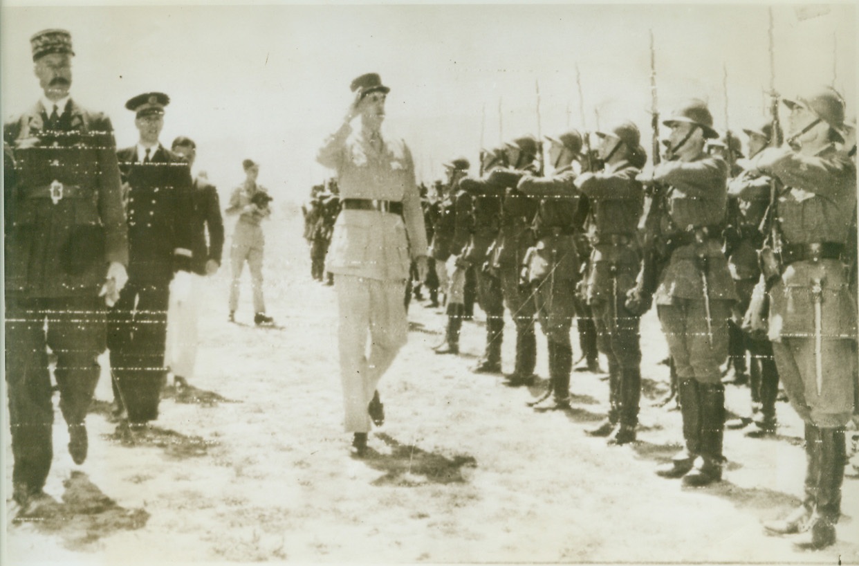 FIGHTING FRENCH HAIL DE GAULLE, 5/31/1943. ALGIERS, N. AFRICA – Just after his long awaited arrival in North Africa, General Charles De Gaulle (right) returns the salute of Fighting French soldiers as he leaves the airfield outside of Algiers with General Henri Giraud (left). Although Giraud made no announcement of the May 30th arrival of the Fighting French leader, Algerian crowds quickly discovered his presence and ignored bans on public demonstrations by shouting: “Vive De Gaulle.” Credit: OWI Radiophoto from ACME;