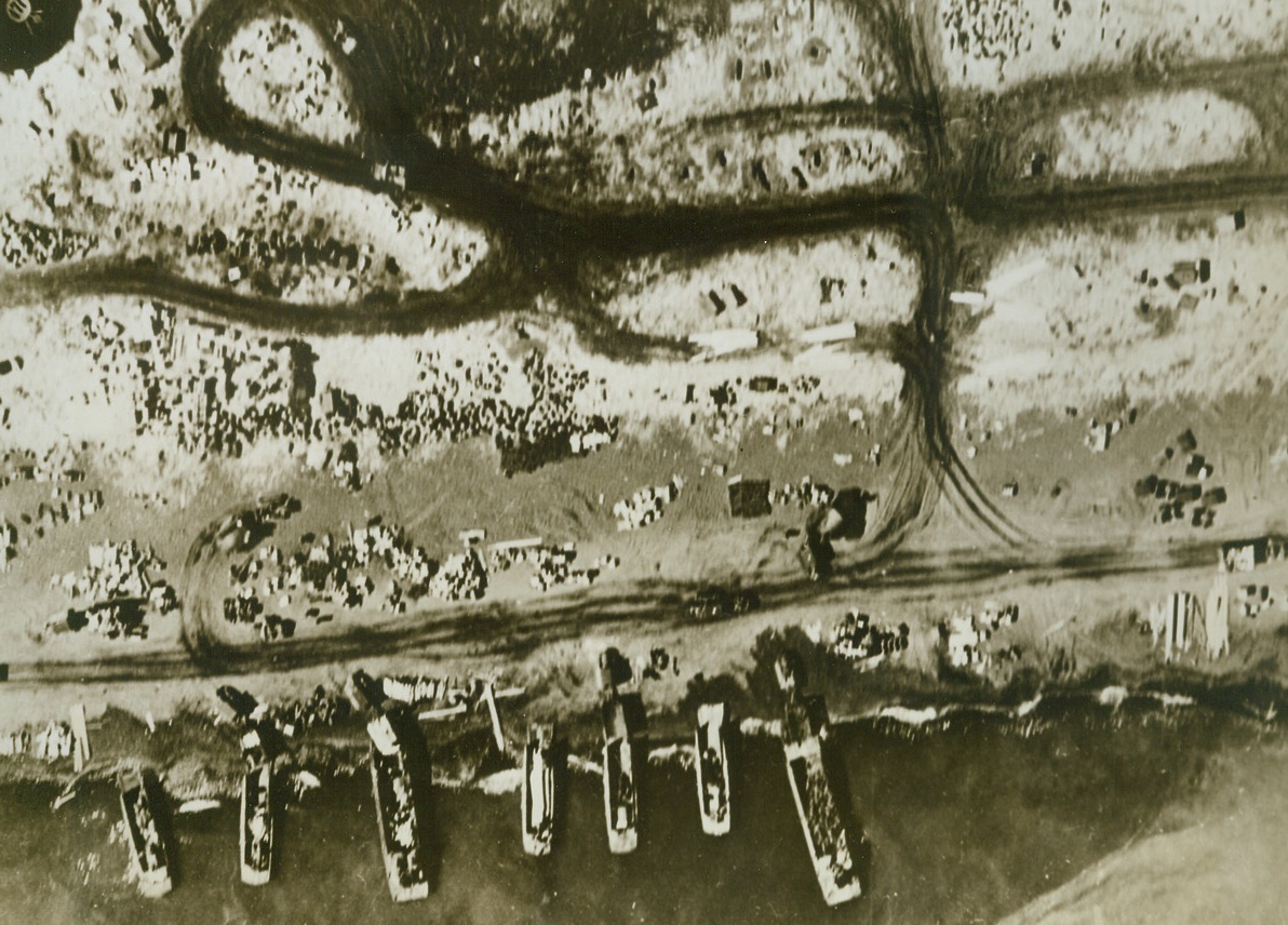 Supplies Come to Attu, 5/29/1943. Attu- - Crates of supplies litter the beach of Attu as landing barges bring more supplies ashore to American fighting men.  The equipment will  be carried inland over newly constructed roads, which are the dark strips that wind across the top of photo.  Latest reports from Attu indicate that the beleaguered Japs in the Chicago and Sabana Bay areas again gave ground before assaults of American troops, now inching their way forward to eliminate the remnants of enemy forces still holding positions on the Island.Credit Line (Official U.S. Navy photo from ACME);