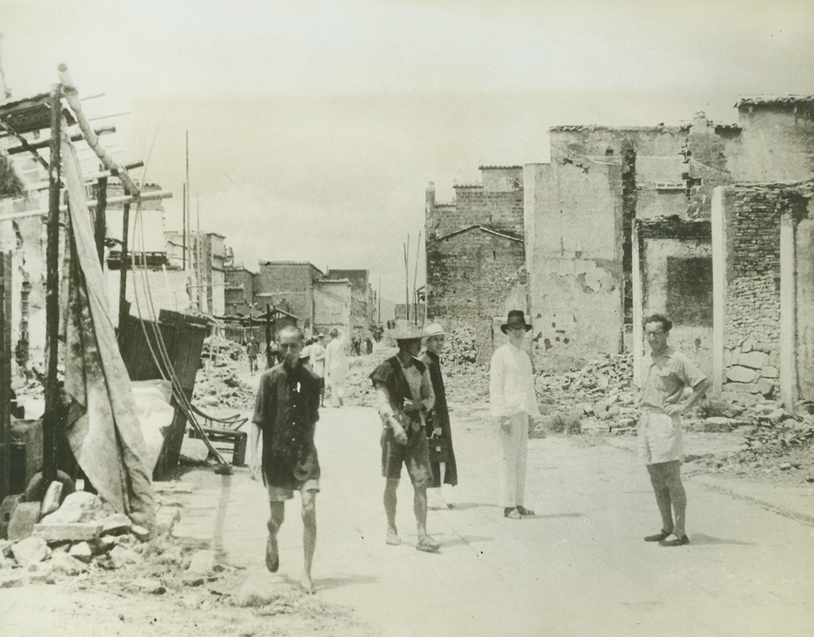 JAP SAVAGERY IN KIANGSI PROVINCE, 5/21/1943. From the camera of Vincentian priests, who served as missionaries in the Chinese Province of Kiangsi in October, 1942, when savage Jap troops visited the countryside to bring death and destruction to tiny towns that gave aid to General Jimmy Doolittle and his men, comes an eloquent record of the sufferings of the Chinese at the hands of brutal, vengeance-seeking Japan. Brought out of China by three priests and five American Sisters of Charity, who hid in the hills while the towns were laid waste, the pictures show violence that far surpasses damage done in modern bombing raids. The Chinese were tortured savagely and put to death en masse. Although the Japs had two objectives-the air field and 200 miles of railroad from Ying-tan to Chin-nua in Chekiang the general conduct of the rail was a punitive one, for it was here that American fliers were fed and treated after their raid of April 18, 1942. Fleeing China after the raid, the eight missionaries traveled on foot, by bus, and finally by boat and plane, reaching the Western Hemisphere five months later. The pictures were obtained in St. Louis from Father Paul Lloyd, director of the Vincentian Foreign Mission Society, and Father George Yager, the Vincentian priest who witnessed the raid and supplied captions for the following photos.  Father Frederick Maguire of Philadelphia (third from left) Father Tom McManus of Ireland (center) and an unidentified doctor in Nancheng (not Nanchang) survey the ruins the Japs left behind as they prepare to do relief work. Two Chinese villagers, who were among the few survivors of the vicious raid, walk dejectedly past the wrecked buildings.  Credit: ACME.;