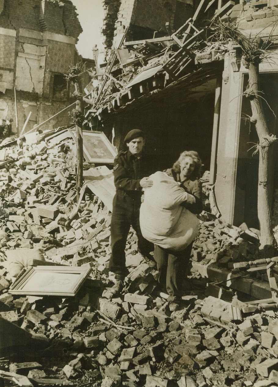 Smilin’ Thru, 5/23/1943.  London, England - Smiling cheerfully as she salvages her belongings from a bomb-wrecked home, this woman is typical of the average Briton. Not even nuisance raids by enemy bombers can shake British confidence in eventual Allied victory. With all Africa conquered and Nazi Europe trembling before the threat of Allied invasion, she knows that it’s only a matter of time ‘till the Axis surrenders - unconditionally. The German Air Force flew over England again, tonight (May 23), in more that a “nuisance” raid. Bombing and strafing two coastal resort towns, Nazi bombers carried out one of the worst raids since the Battle of Britain. Credit: ACME;