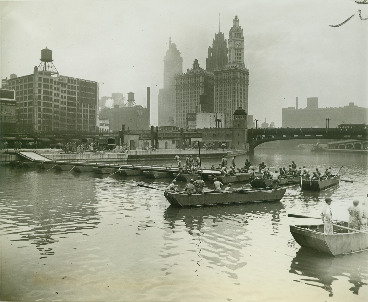 ARMY BRIDGES CHICAGO RIVER IN 55 MINUTES, 6/16/1943. CHICAGO – In a little less than an hour, U.S. Army engineers from Camp McCoy, Wis., built across the Chicago River at State Street a pontoon bridge capable of carrying a load of ten tons, and within another hour had dismantled it. The demonstration was made in celebration of the Engineers 168th anniversary. Credit: OWI Radiophoto from ACME;