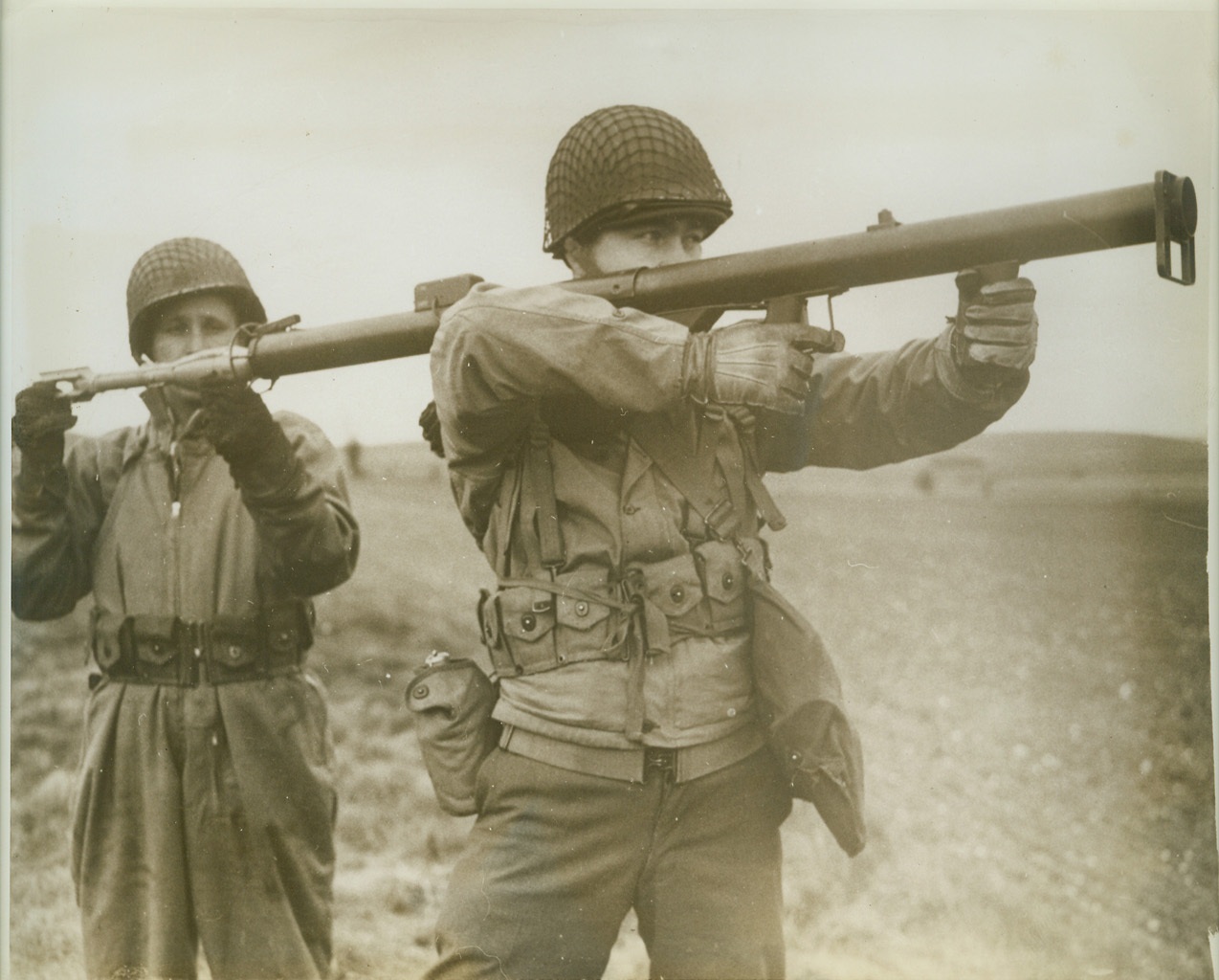"Bazooka" Boys, 6/5/1943. SOMEWHERE IN ENGLAND -- Tho' it looks like something an imaginative youngster rigged up to play "war", this is America's latest weapon -- the "Bazooka" gun. Lt. Carl Peterson, of Dearborn, Mich., fires the gun, which sends a destructive rocket whistling toward doomed tanks and pillboxes, as Corp. Albert Salo, of Ironwood, Mich., loads the weapon. Credit: (ACME);