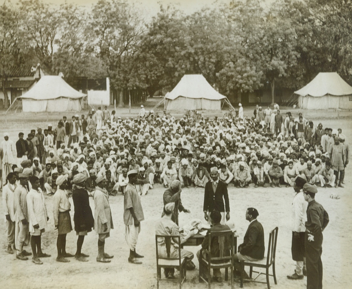 It’s Pay Day, 6/7/1943. India – Here is the monthly pay day and prize presentation on the parade ground at a U.S. Air Depot that is now being built with the help of native workers in India, the two best teams of the month get prizes and pay raises.  Most popular prizes are cotton gloves which enable the men to do the work better.  It has been found that this system of payment is a great improvement over the contract labor method where the contractor takes a cut out of each pay check.Credit Line - -WP- -(ACME);