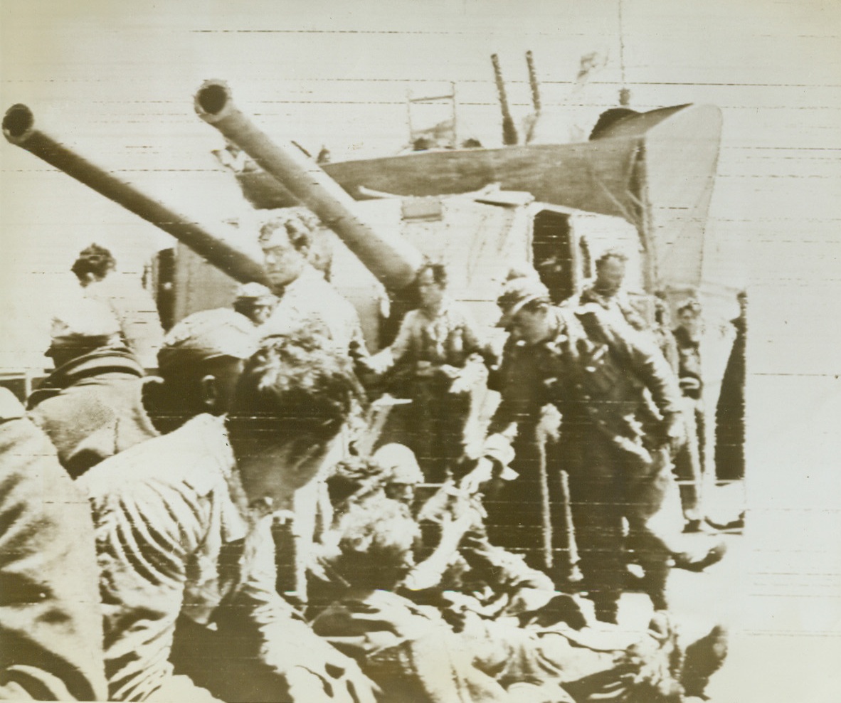 Nazis Fed Under Warning Guns, 6/1/1943. A group of Nazis who attempted to flee Tunisia via water are fed under the guns of the allied naval vessel responsible for their capture.  Hundreds of Germans attempted to flee the scene of their defeat in North Africa, constructing makeshift rafts; patching up small boats in vain.  After rounding up and feeding them, allied naval forces transferred them to barges to be taken back to Tunisia as prisoners of war. Credit (U.S. Army Signal Corps radio telephoto);