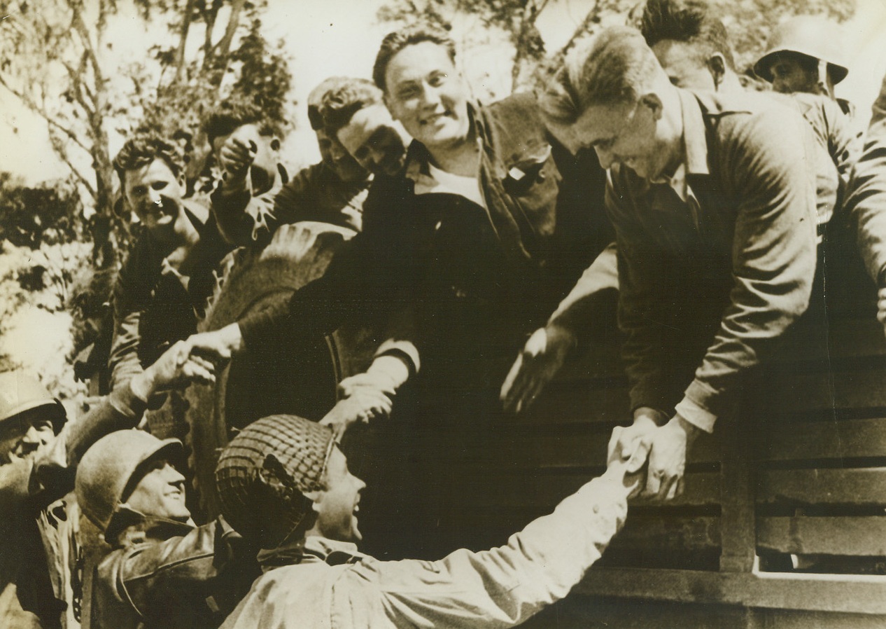 Back in the Fight, 6/16/1943. Joyously bidding their American buddies farewell, these Soviet soldiers are heading back to their homeland to fight the Nazis once again under the Red Star of Russia. Captured on the Soviet front, they were sent to Axis prison camps in North Africa, from which they were freed when the Allies took over their territory. Credit: Official OWI photo from ACME.;