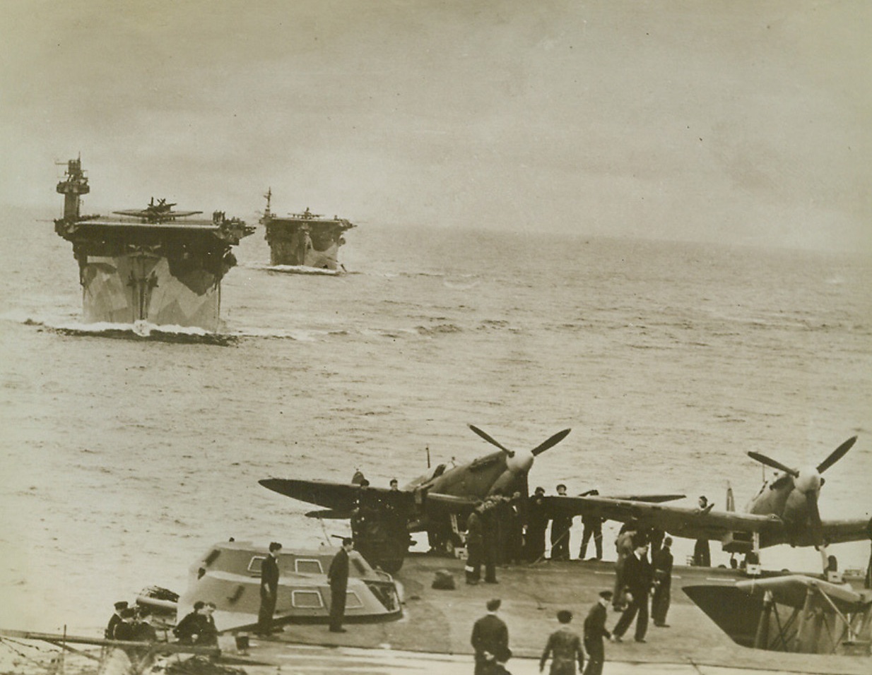 An Answer to the U-Boat Menace, 6/10/1943. Here’s one of the United Nations’ answers to Axis U-Boats that menace Allied shipping. These new type escort vessels carry planes to battle both underseas and aircraft when they attack on the high seas. Made from the deck of the (illegible word) Victorious, photo shows the (illegible word) Biter and Avenger. All three carriers offer protection that has reduced loss of convoy cargo considerably.  Credit: ACME.;