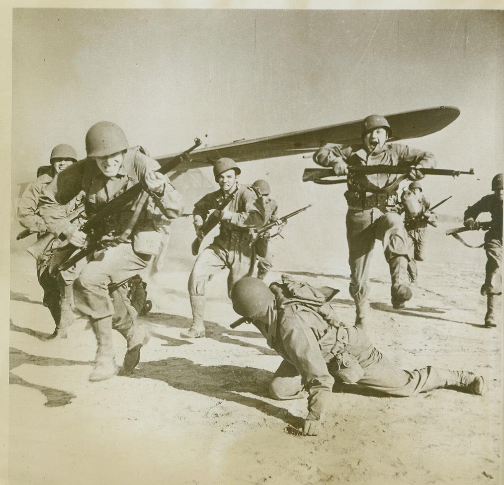 Glider Troops Prepare for Invasion, 6/28/1943. A U.S. GLIDER SCHOOL—Glider troops, in training at a glider activity base in the United States, practice charging the “enemy” after landing in their bomber-towed glider. These huge gliders, “freight cars” of the air, can carry 15 fully-equipped troops, a Jeep, or field artillery. They are being built in ever-increasing quantities in preparation for the coming invasion of Nazi-dominated Europe. Credit: (U.S. Army Air Corps Photo from ACME);