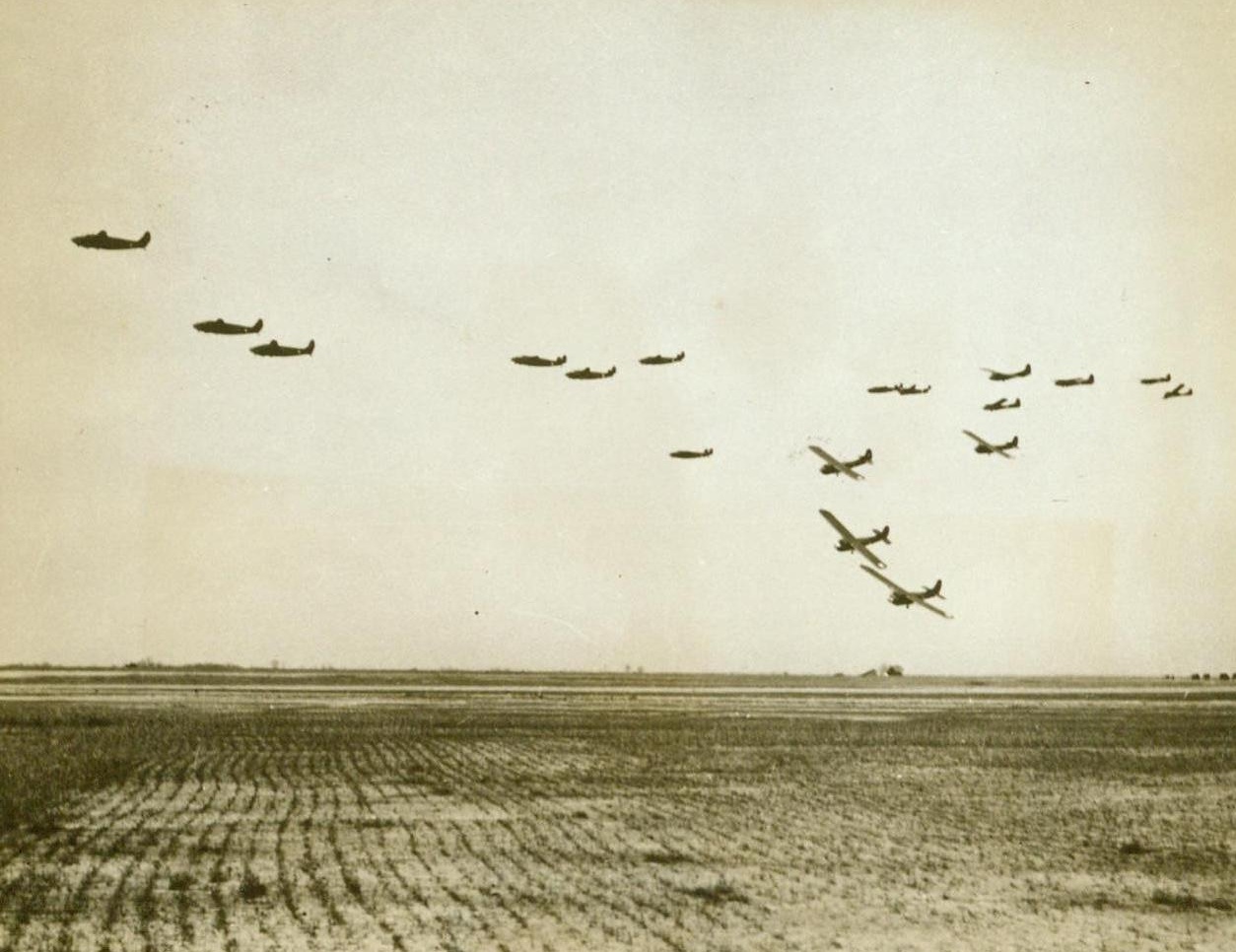 Glider Troops Prepare For Invasion, 6/28/1943. A U.S. Glider School – Gliders, flying “freight cars” which can carry a jeep, field artillery, or a compliment of 15 men equipped as shock troops, peel off from formation to land, after releasing tow ropes attached to the bombers that towed them. These gliders are being used at a Glider Activity School in the United States, where glider troops are training for the coming invasion of Nazi-occupied Europe. 6/28/43 (ACME);