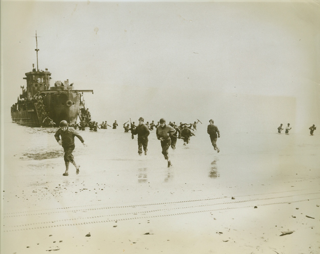 Training For Invasion By Sea, 6/17/1943. SOMEWHERE ALONG THE ATLANTIC COAST  - Streaming into waist-deep waters from an L.C.I. (Landing Craft: Infantry), U.S. Army troops "hit the beach" during practice invasion maneuvers along the Atlantic Coast. Training to strike as a strong, well-drilled invasion spearhead, these men will form part of a unified Army-Navy amphibious force to storm enemy strongholds from the sea.;