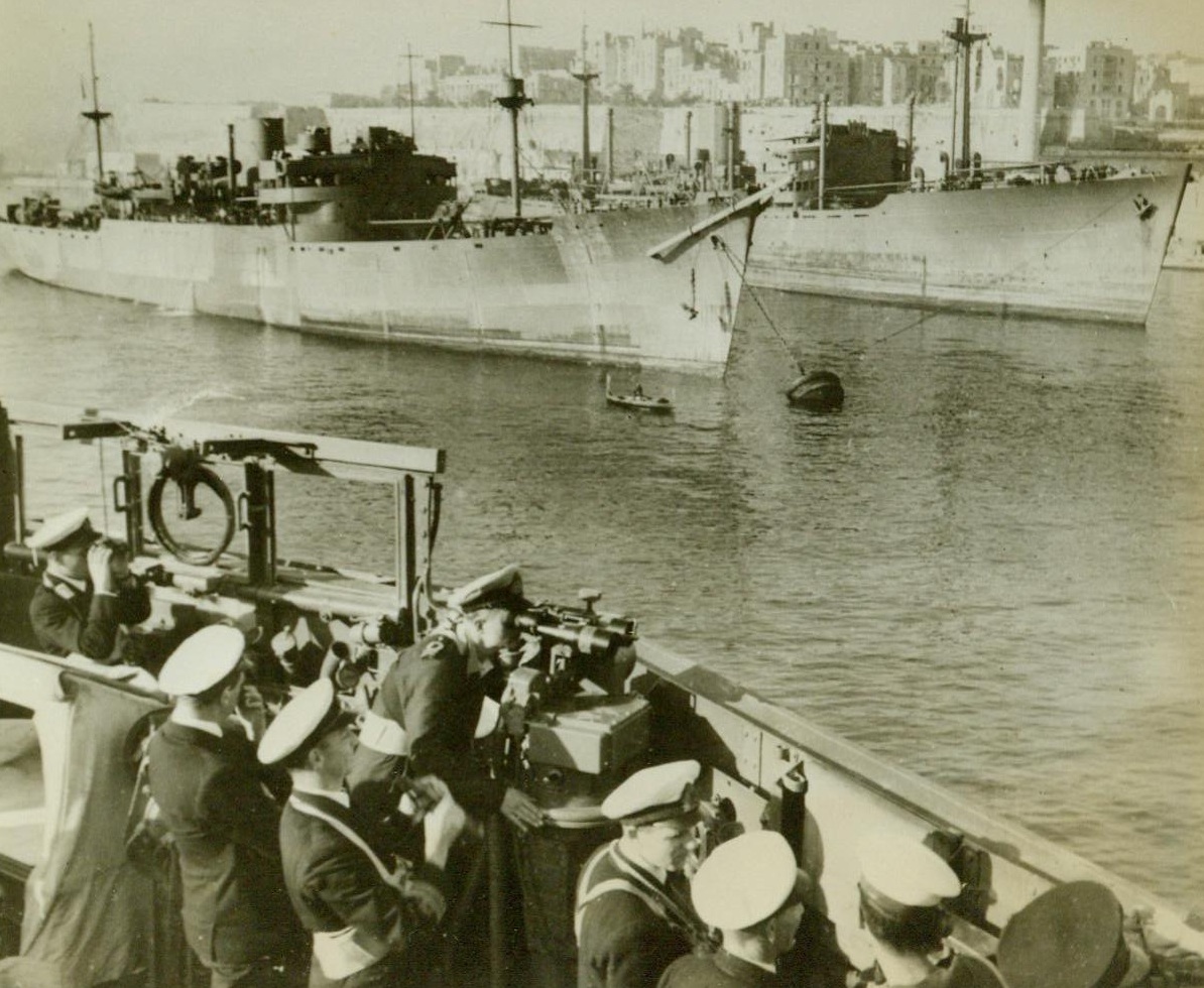 Convoy Reaches Malta, 1/17/1943. Aboard A Royal Navy Cruiser – The ships of a Malta- bound convoy anchor in the harbor as they reach their destination safely. Photo was made aboard a British Cruiser that accompanied the convoy. 1/17/43 Credit Line (ACME);