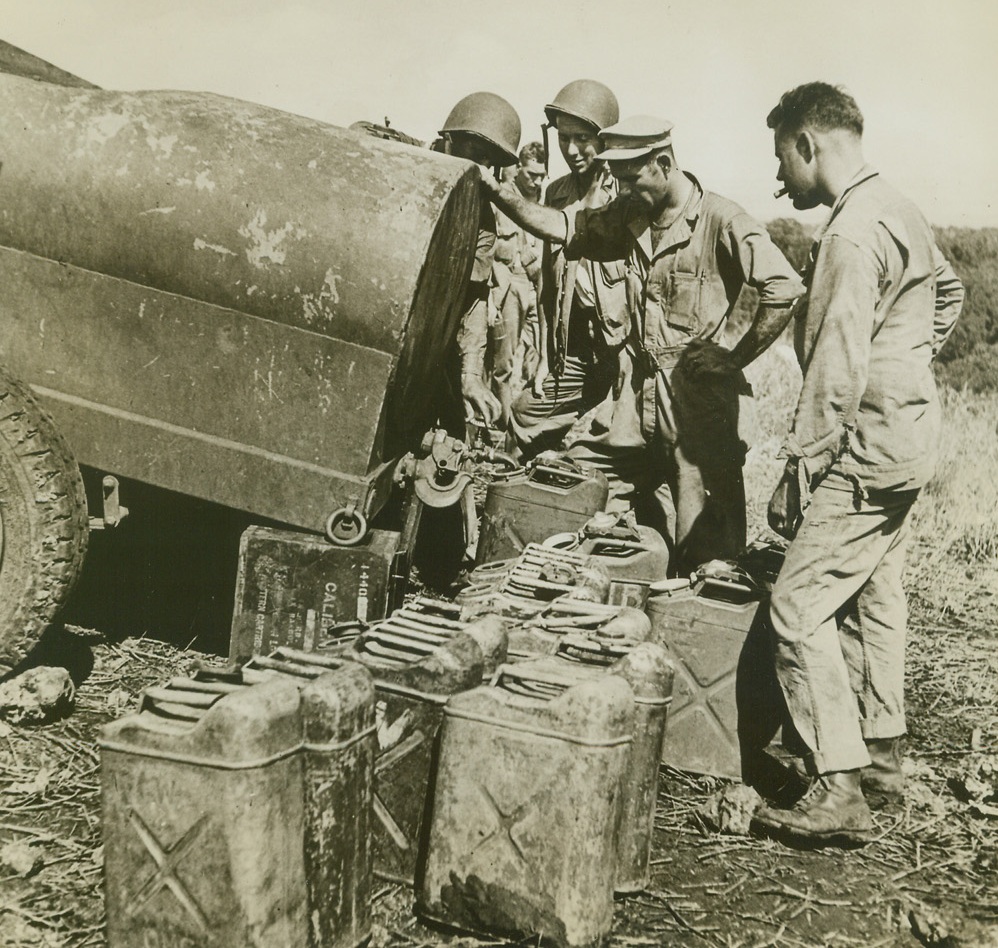 WATER FOR THIRSTY U.S. FIGHTERS, 1/26/1943. GUADALCANAL—Five gallon cans are filled with water at this last outpost—the end of the jeep trail on Guadalcanal. The cans are then carried forward to combat areas, where U.S. ground forces are battling the Japs. Today, American troops wiped out 293 more Nips and consolidated their position at Kokumbona. Credit: Acme;