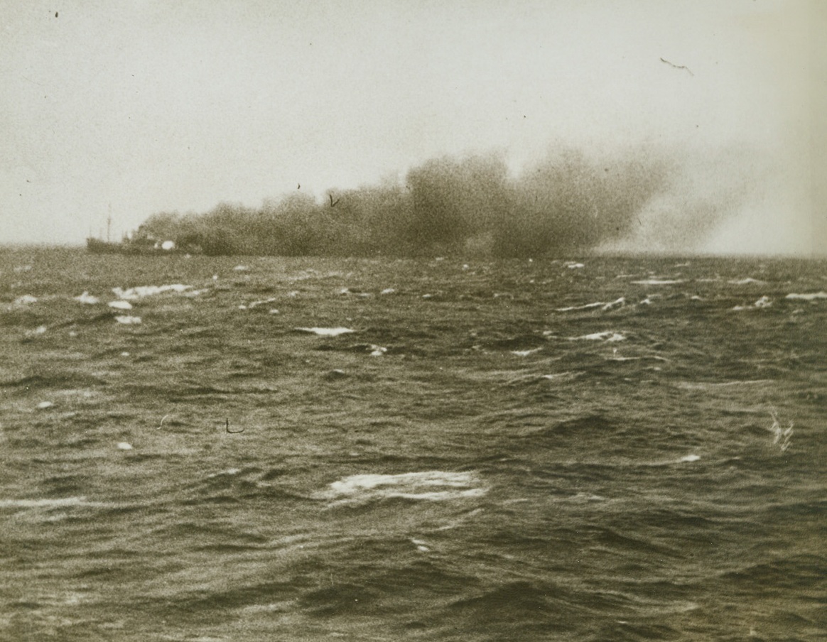 Nazi Ship Burns and Sinks, 1/17/1943. Bay of Biscay – A German blockade runner slowly sinks in the waters of the Bay of Biscay, leaving a trail of black smoke from her burning deck behind her, after being shelled by the H.M.S. Scylla.  Heavily laden with raw materials for Germany, the blockade runner was first sighted by a Wellington of the R.A.F. Coastal command, which attacked, unsuccessfully, in bad weather.  A Sunderland was then sent to guide the Scylla to the Nazi vessel, and the British ship sent her to the bottom as she neared the last lap of her journey.Credit Line (ACME);