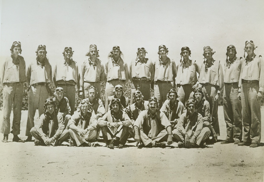 They Served Their Country, 1/10/1943. Midway Island – Gathered on the sands of Midway, shortly before the battle that ended in a great American victory last June 4-6, are these pilots of Marine Scout Bombing Squadron  241, part of Marine aircraft group 22. All but two of the men shown here participated in the engagement, and were the first to hit the Jap carriers.  The squadron paid heavily in casualties, and many of its members are listed as “missing in action” and presumed lost.  All of the pilots and aerial gunners of squadron 241 have been decorated for their heroic achievements in the battle of Miday. (Note: (M) indicates missin, and (w) indicates wounded) left to right: (first row) Second Lt. Albert W. Tweedy (M); Captain Bruce Proesser; Major Lofton R. Henderson (M); Major Leo Smith (did not participate); Captain Elmer Glidden, Jr. (Second row) Second Lt. Thomas J. Gratzek (M): Second Lt. R.W. Vaupell (W); First Lt. Daniel Iverson, Jr. (W); Second Lt. Jesse D. Hollow, Jr.; Second Lt. Howard G. Schlendering (W); Tech, Sgt. Clyde Stamps; (rear row) Second Lt. M. A. Ward (m) Captain R.L. Blaine (W): Second Lt. S.H. Whitten; Second Lt. T.F. Moore, Jr. (w); Captain A.H. De Laeio (w); Second L. Bruce H. Ek (M); Captain L.M. Williamson; Second Lt Bear; Marine gunner Howard Fraser; and Second Lt. Bruno P. Hagedorn (m).  Last man in rear row is unidentified. Credit Line (U.S. Marine Corps photo from ACME);