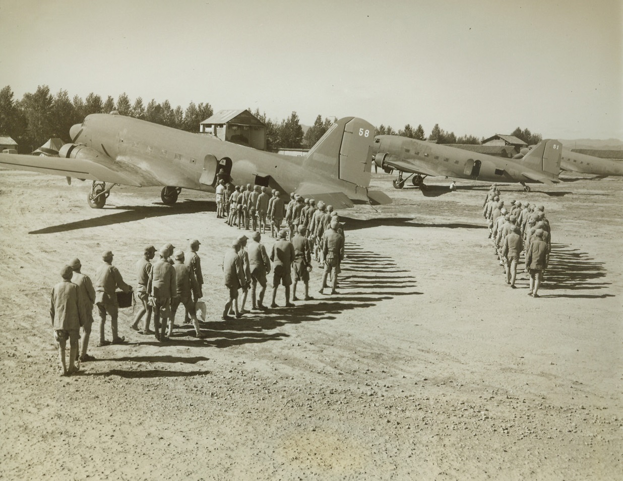 American Transports Fly Chinese Troops, 1/13/1943. Somewhere in China – Chinese troops march to American troop transports, of the India-China ferry command, to be flown to scattered combat fields and training centers.  They board the big ships “somewhere in China.” Credit line (ACME);