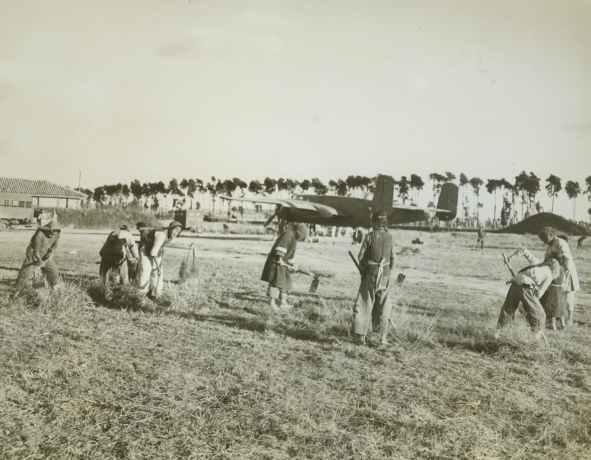 Chinese Women Work on American Airfield, 1/13/1943. Somewhere in China – Using hoes and scythes, Chinese women and children clear the ground to enlarge an American airfield in China.  They consider it their patriotic duty to work for their country and to assist the Americans who are their allies. Credit line (ACME);