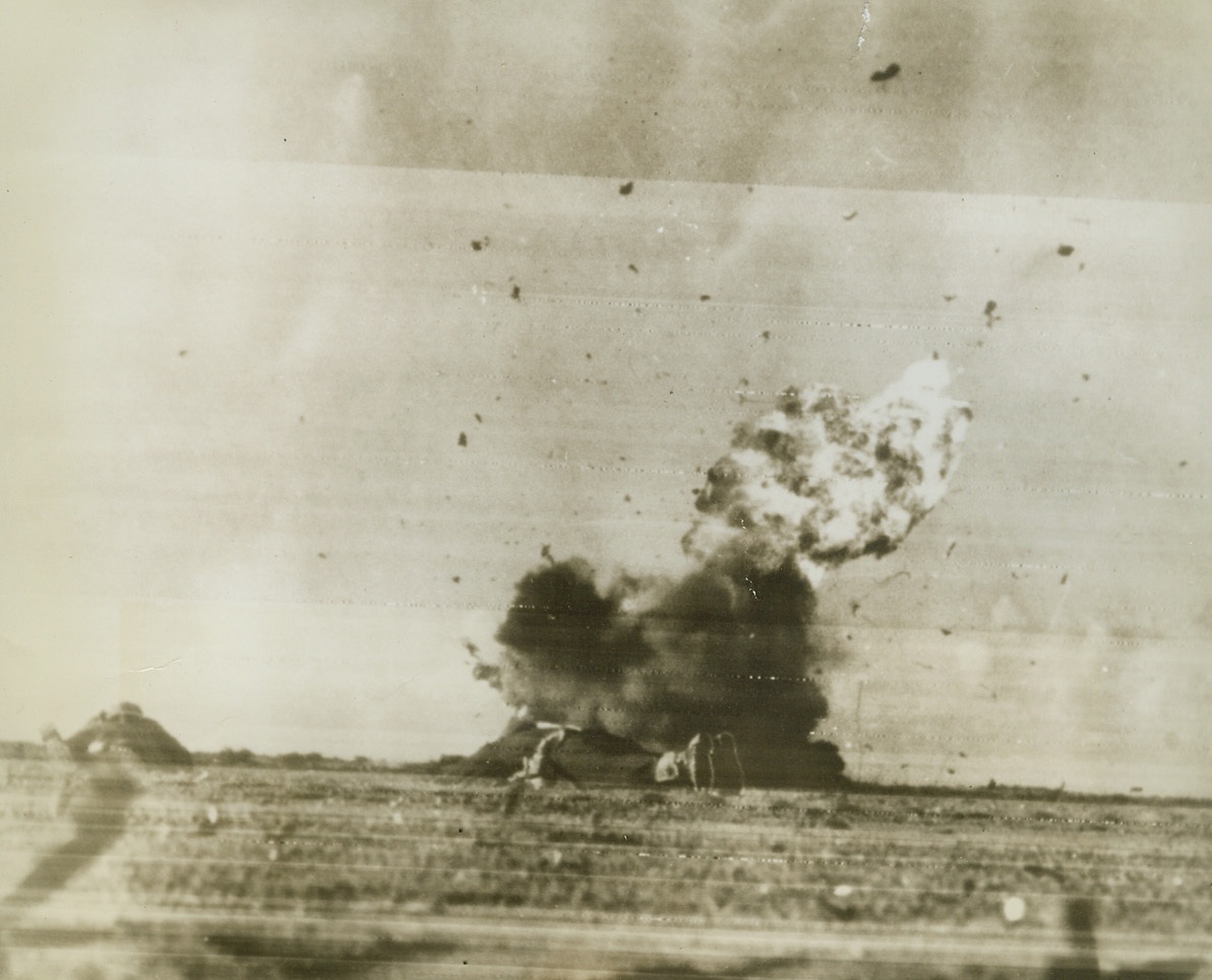 Western Desert—Graveyard for Axis Planes, 1/12/1943. An Axis plane crashes in flames in the desert and Allied soldiers do a speedy bellyflop to escape the far-flung wreckage. Allied troops from east and west continue to stab at the weakened Afrika Korps.Credit: New Zealand Public Relations-ACME.;