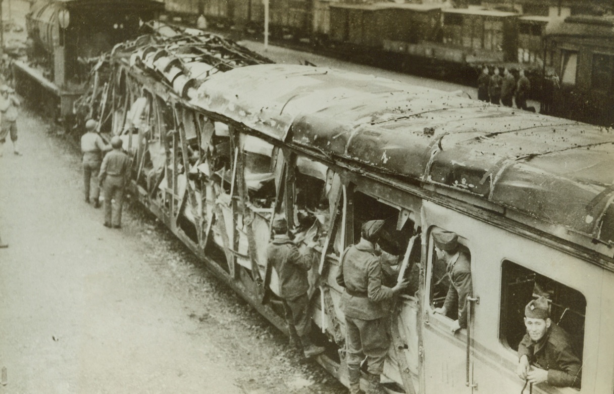 German Planes Blast Red Cross Train, 1/14/1943. Tunisia—Soldiers exam the remains of a Red Cross train which was blasted by German planes in Tunisia, despite the fact that cars were clearly marked on top with Red Cross symbol. Note Red Cross atop cab (top center in photo). (Passed by censors).Credit: ACME.;