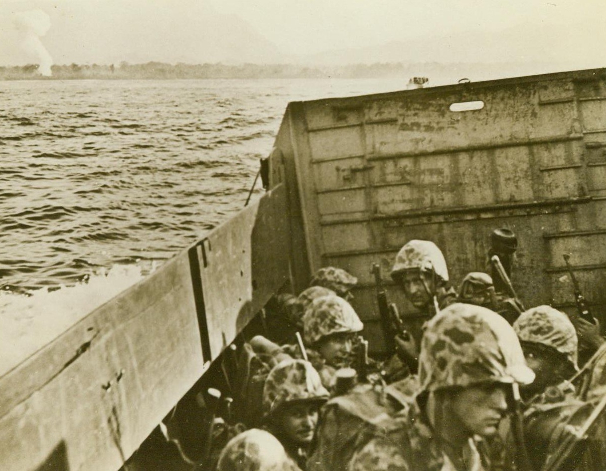 Ready For The Jungles Of Bougainville, 1/23/1943. South Pacific -- Crouching low in their landing craft, U.S. Marines approach Empress Augusta Bay, Bougainville Island, in the South Pacific. They are ready with camouflage suits for the jungle fighting that followed the rushing of the beaches. 1/23/43 (ACME);
