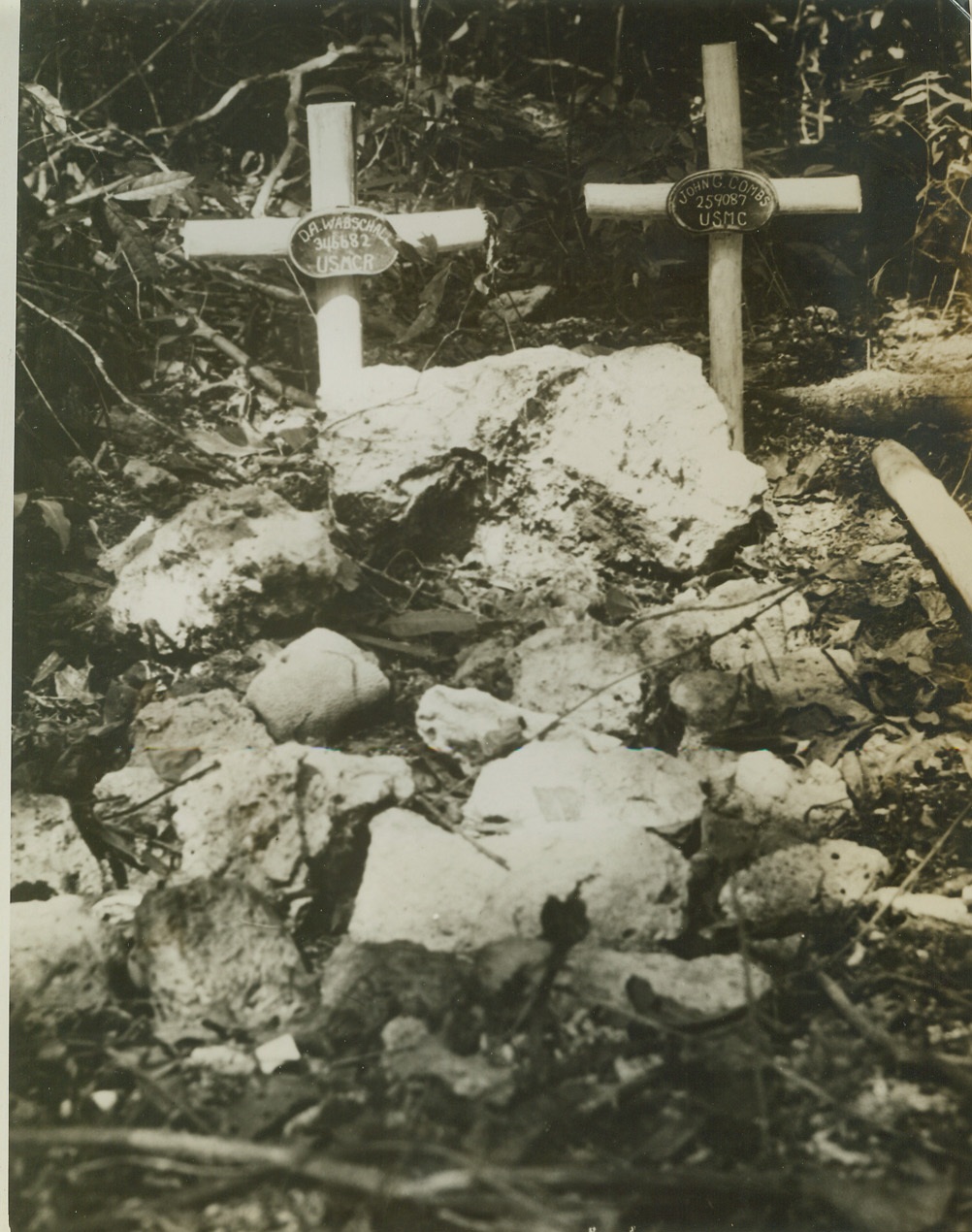 These are the dead, 9/24/1943. ENOGAI, NEW GUINEA - This is the last resting place of marines who gave their lives for their country during fighting in the Enogai jungle. Given a Christian burial by Marine Corps chaplains, the boys lie in neat graves marked with name plates made from captured Jap mess gear.;