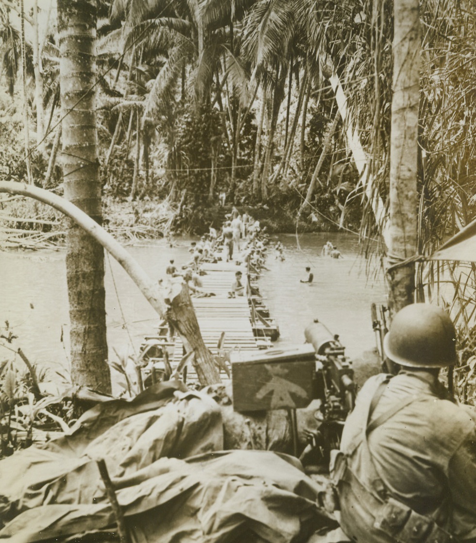 GUARD OF THE BATH, 9/24/1943. IN THE SOUTH PACIFIC—While Marines of an engineering battalion take much-needed baths in this jungle stream on a South Pacific Island, a machine gunner stands guard over his bathing buddies. Should a Jap patrol or a sniper appear on the opposite bank, his trusty gun wil go into action immediately.Credit: U.S. Marine Corps photo from Acme;