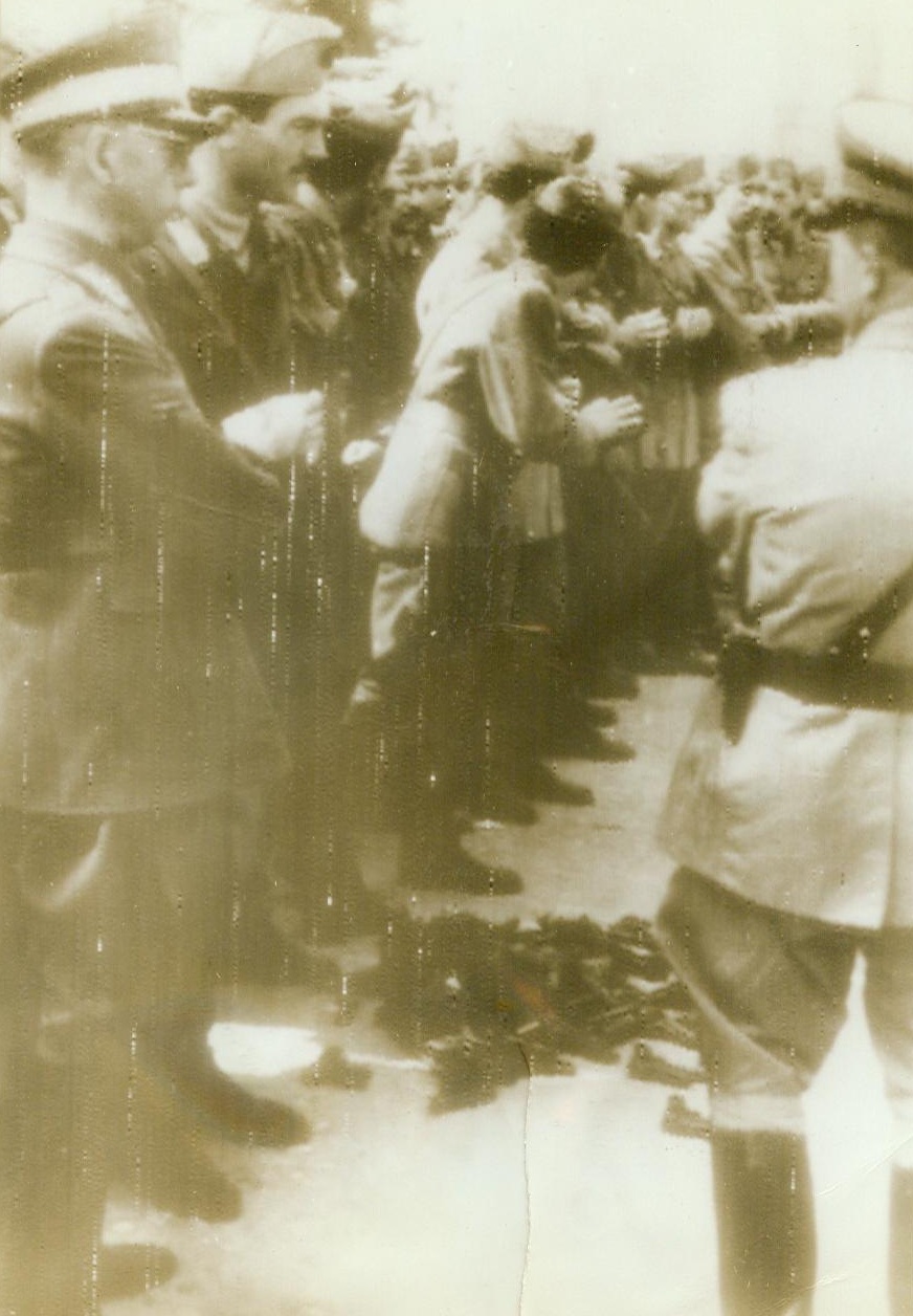 AXIS PARTNERSHIP DISOLVED, 9/14/1943. New York: -- According to the German caption accompanying this picture, which was telephotoed to Stockholm and radioed to New York today (Sept. 14), Italian officers a lined up in Parma, in northern Italy, being disarmed by their one-time Nazi allies. On the ground is a stack of revolvers surrendered by the Italians. Credit (ACME Radiophoto);