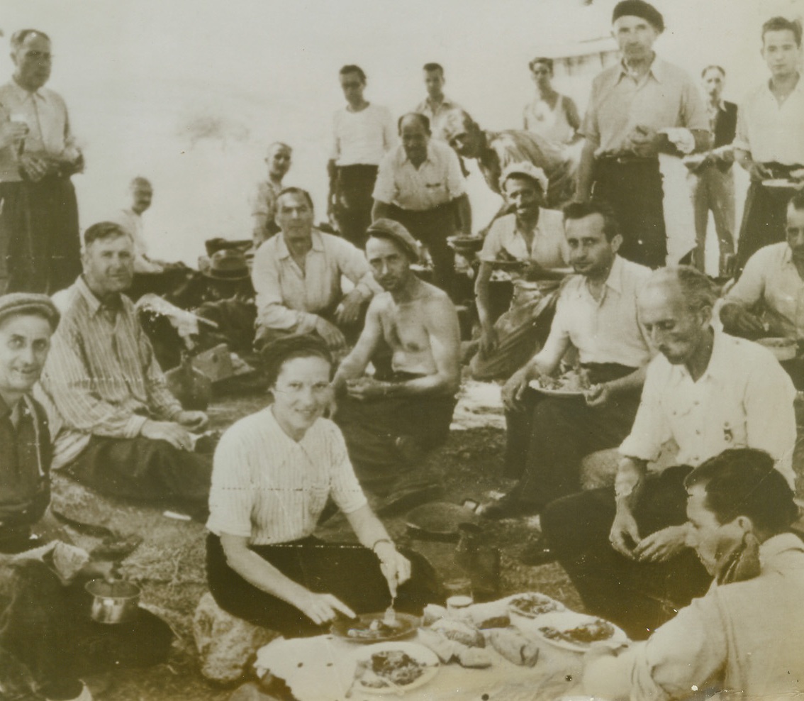 Freedom Picnic for Corsicans, 9/22/1943. This photo, flashed to New York by radio today, shows a group of French Corsicans as they enjoyed their first meal in Italy after their liberation from Axis captors by the Allied invasion. Today it was announced that U.S. Rangers had joined French commando troops in mopping up the remaining German forces in Corsica. (A British Army film unit photo). Credit: OWI radiophoto from ACME.;