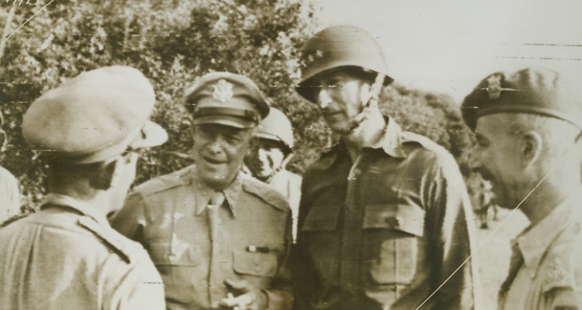 “Pep Talk” on the Italian Front, 9/22/1943. Gen. Dwight D. Eisenhower, (second from left), commander-in-chief of Allied forces in the North American Theatre; and Lt. Gen. Mark W. Clark, (second from right), commanding general of the U.S. 5th Army, confer with two British generals “somewhere on the Italian front,” in this photo, flashed to the U.S. by radiotelephoto today, as it was announced the Allies had almost reached Naples. Credit: U.S. Signal Corps radiotelephoto from ACME.;