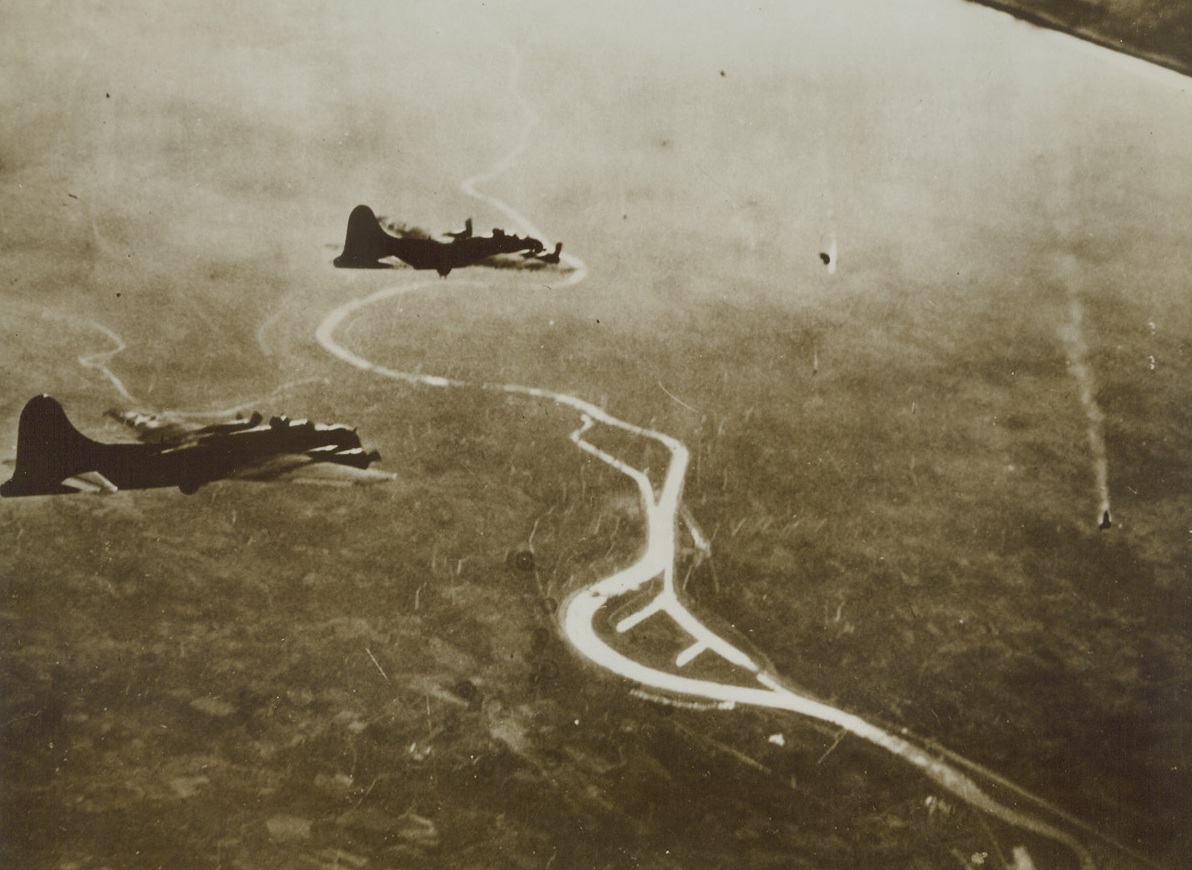 Nazi Planes Scatter – in Pieces, 9/2/1943. GERMANY—Flaming pieces (right) mark the end of a German Messerschmitt 110 during a Flying Fortresses attack on the ball-bearing factory at Schweinfurt. August 17, when the 147 Nazi Fighter planes. The fierce daylight battle raged for hours amid scenes like this one where the massed fire power of the famous bombers is too powerful for the enemy flying resistance.  Credit: ACME.;