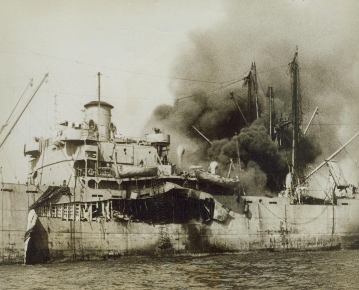 VICTIM OF A NAZI BOMB, 9/30/1943. SALERNO, ITALY—An Allied merchantman is blown wide open by a Nazi bomb as our forces effected their landings at Salerno under a barrage from enemy shore batteries and bombers. Credit: Newsreel pool photo from Acme;