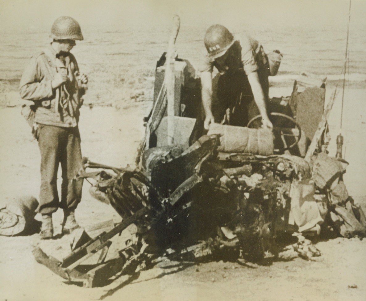 When Jeep Meets Mine, 9/30/1943. SALERNO – This is what happened when an American Jeep met a land mine, buried in the beach, during the invasion of Salerno. A soldier and a member of a Navy beach party examine the wreckage. Credit Line (U.S. Coast Guard Photo from ACME);