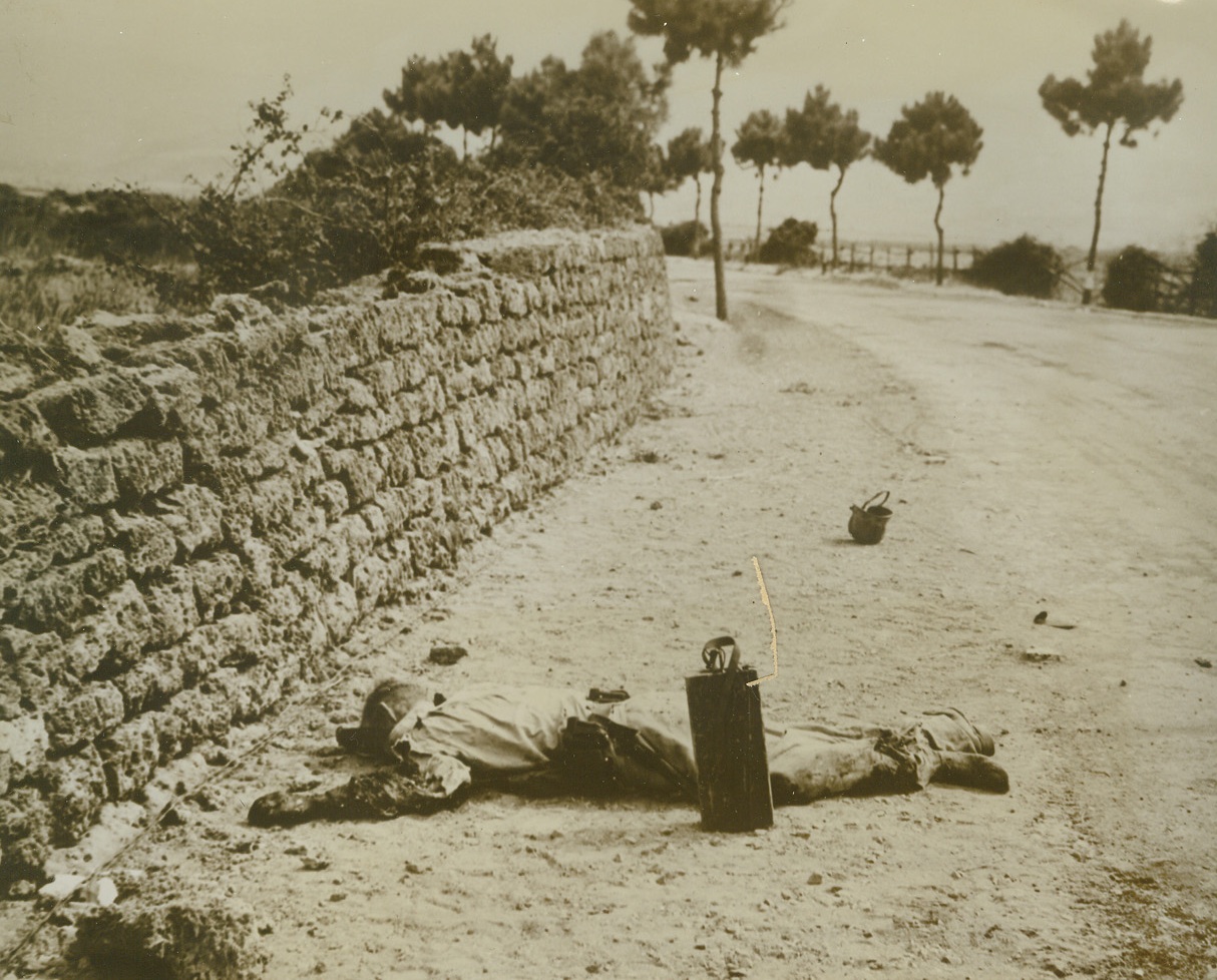 He Didn’t Make It, 9/25/1943. AGROPOLI, ITALY – This Nazi soldier was cut down by American gunners as he was about to vault over this protective wall on the road to Agropoli. The German was laying mines along the road when he was killed. He fell with such force that his helmet landed several feet away. Credit Line (Official Navy Photo from ACME);