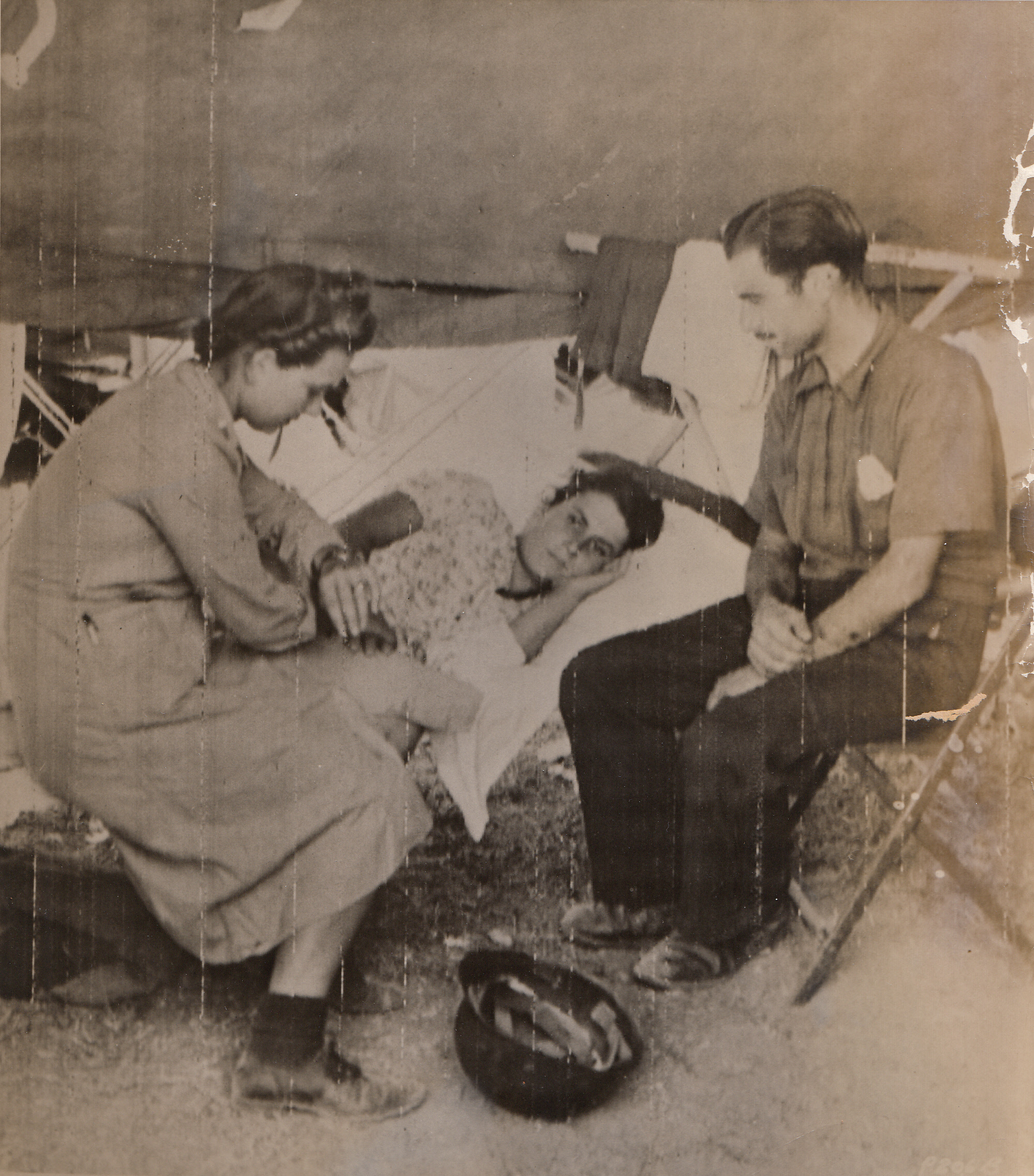 U.S. Army Nurse Treats Italian Civilians, 9/29/1943. This photo, flashed to the United States by Radiotelephoto and made during the Italian campaign, shows how U.S. medical corps units in Italy are treating injured civilians as well as soldiers. An Italian woman, hit by shrapnel from a German bomb burst, receives treatment from Lt. Ruth Lee, at a U.S. Field Hospital. Her anxious husband watches as her pulse is taken.;