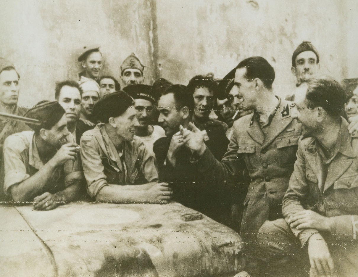 No Hard Feelings, 9/7/1943. ITALY – No official interpreter is needed for Italian soldiers and sailors to tell Royal Air Force airmen that they are glad to be captured, near Reggio Calabria, because it means they are out of the war. Taken by a British RAF photographer, this photo is a first shot of action to follow the invasion.Credit (OWI Radiophoto from Acme);