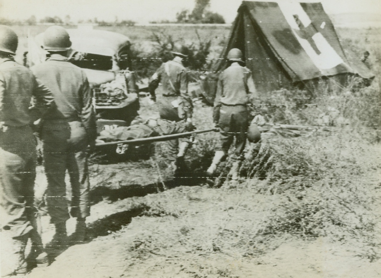 First Aid for American Wounded as we Invade Italy, 9/13/1943. The above picture flashed to the United States by Radiotelephoto shows a wounded American soldier injured during U.S. landing operations on Italian soil is carried to an advance first aid station. Credit Line (Acme photo by Charles Corte for the Picture Pool via U.S. Army Signal Corps Radiotelephoto);