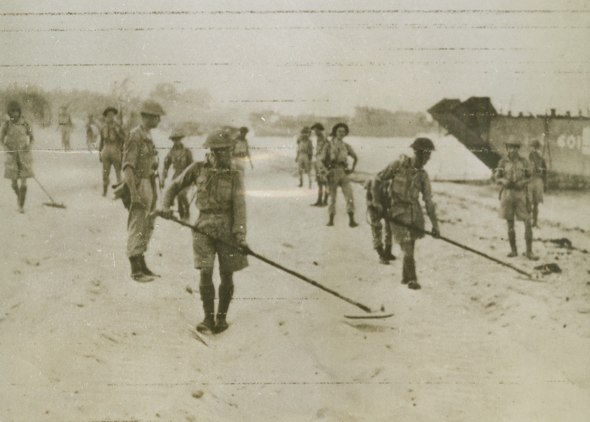 A Bunch of Smart Sappers, 9/7/1943. ITALY – Shortly after landing, British sappers go to work at the ticklish job of clearing the beaches north of Reggio Calabria of mines sowed by the Axis. “Actual” enemy resistance was slight, but mines, demolition of bridges and roadways, and the rough terrain has slowed the steady Allied advance in Italy. This is a first photo of “action” on the continent of Europe.Credit Line (OWI Radiophoto from Acme);