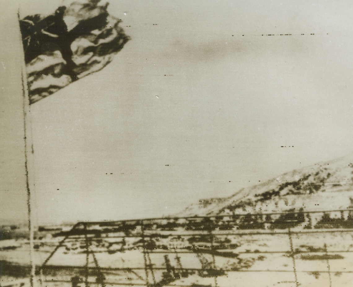 White Ensign Over Italy, 9/6/1943. REGGIO HARBOR, ITALY – The first Allied flag to fly over the Italian mainland, Britain’s white ensign flutters above Reggio harbor. Latest reports indicate that Allied commando raids behind the German lines have resulted in the fall of Melito and Bagnara.Credit Line (Acme Radiophoto);