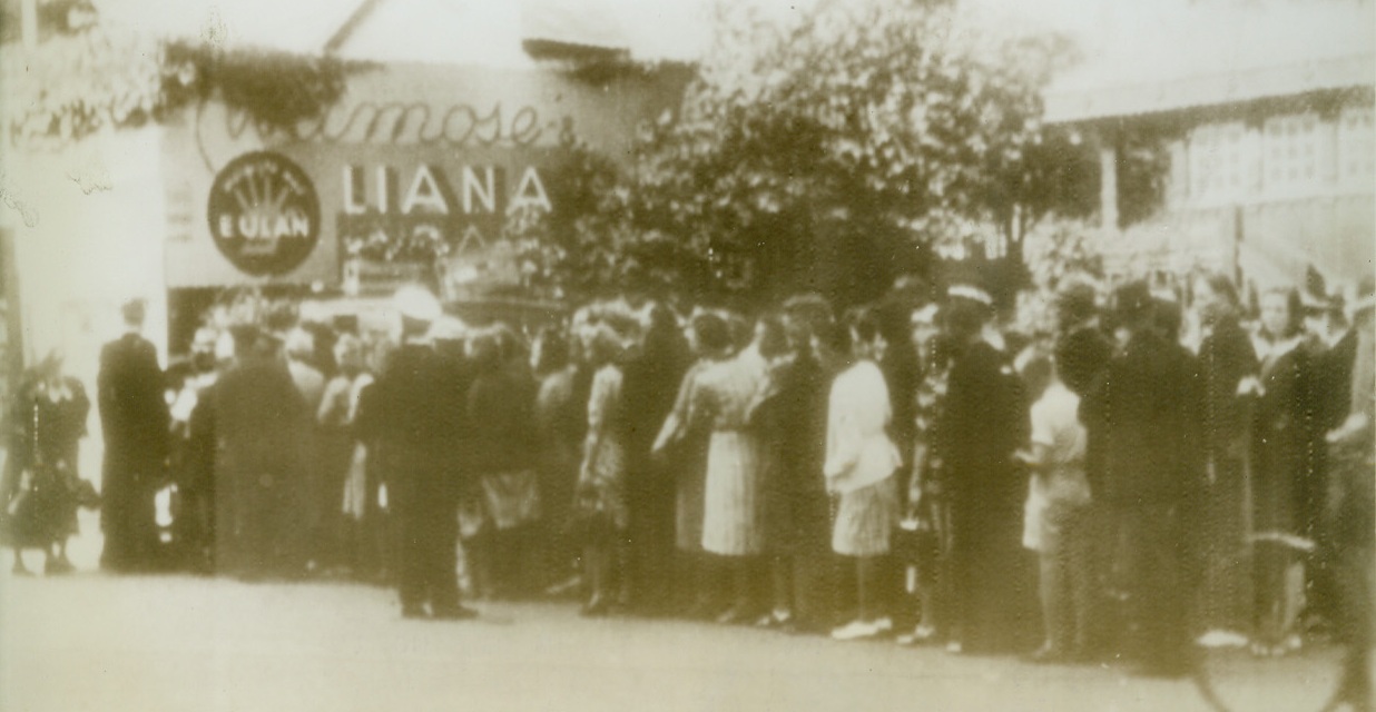 Food Disappears in Wake of Trouble, 9/6/1943. OLDENSE, DENMARK – Nazi-hatred fired Danes into action two weeks ago, and explosions, fires, and violence were the result. A German officer was stamped to death by Danish boots in Oldense, for example, and in the wake of the uprising came great shortages of food. Here residents of Oldense queue up at a dairy shop as Danish policemen supervise after martial law had been declared.Credit Line (Acme Radiophoto);