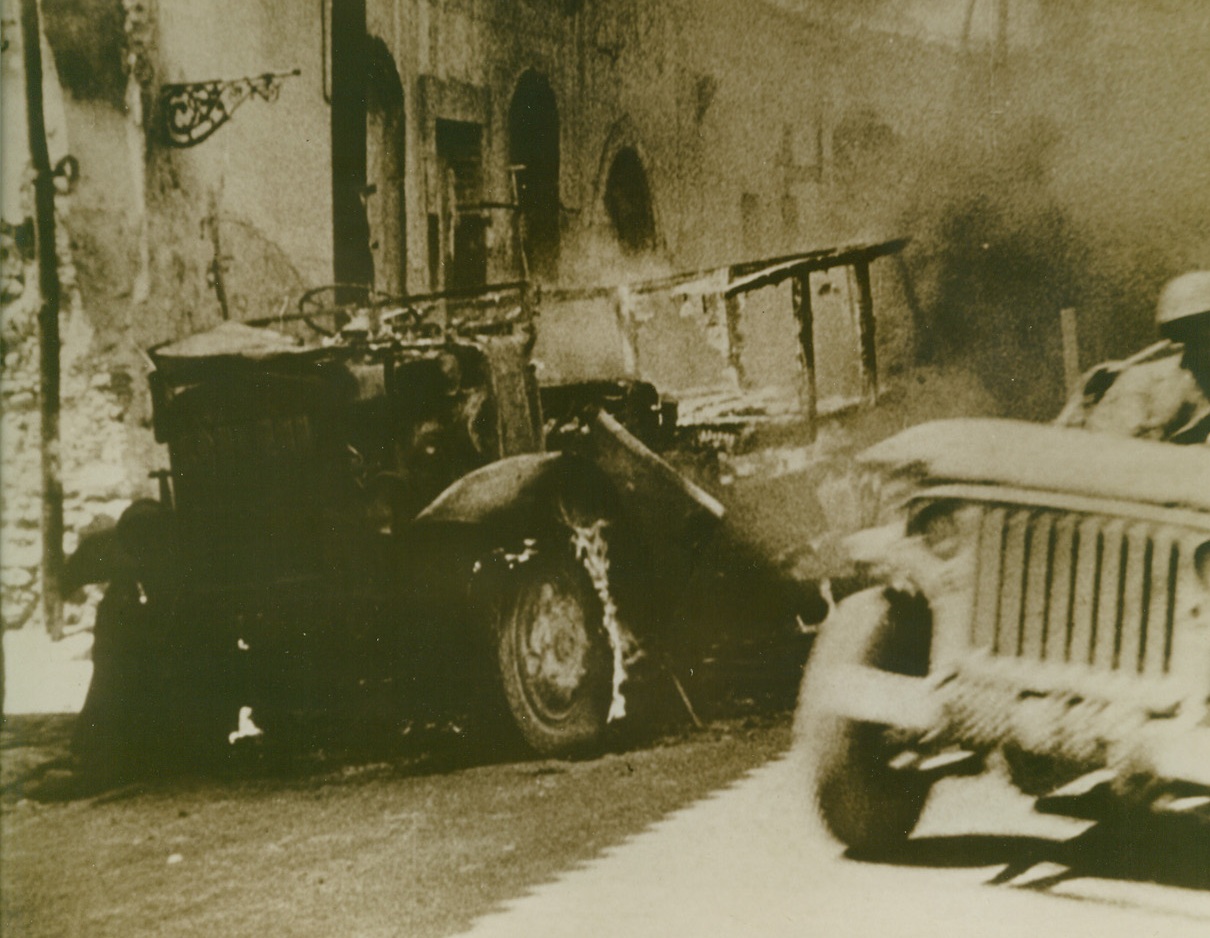 Allies Advance Near Salerno, 9/21/1943. A jeep, (right) loaded with American troops passes a burning Italian vehicle, as the Allies swept through another town in the Salerno area. Today, as Allied forces closed in near Naples, Germans are reported to be looting and killing in that city after setting much of it afire preparatory to abandoning Naples.  Credit Line (U.S. Signal Corps Newsreel from Acme);
