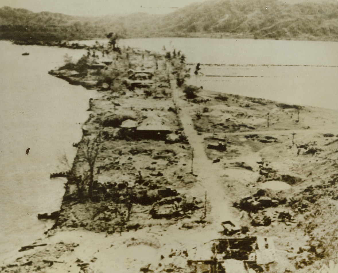 Bomb-Ravaged Salamaua, 9/20/1943. Salamaua – This General view of bomb-ravaged Salamaua shows damage done to the peninsula by our bombs. The truck depot, boat landings, and main Japanese headquarters are completely destroyed 9/20/43 Credit (Signal Corps Radiotelephoto From ACME);