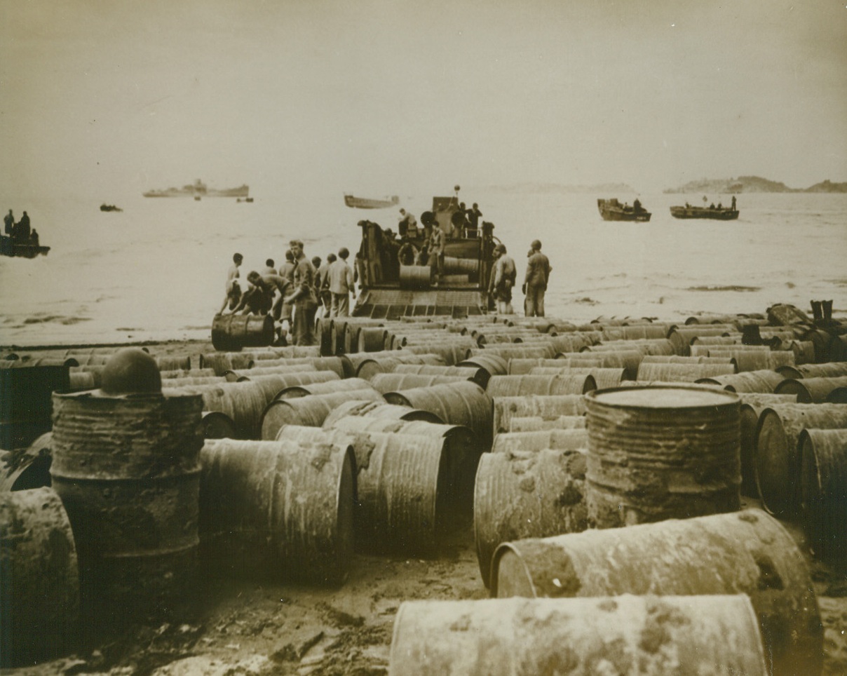Fuel To Keep Leatherneck Tanks Rolling, 9/24/1943. Somewhere In The South Pacific – Hundreds of drums of oil, rolled from a landing lighter, crowd the beach of a South Pacific Island. Awaiting removal by work gangs of the U.S. Marines, the drums of oil will turn the wheels of tanks, boat engines, and jeeps that bring our Leathernecks nearer and nearer to Tokyo.  9/24/43 Credit Line (U.S. Marine Corps Photo From ACME);