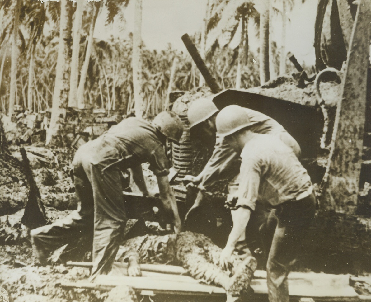He Gave His Life, 9/25/1943. Rendova Island – Yank fighters lift the body of an American soldier from under a truck where the ill-fated doughboy sought refuge during a Jap bomber raid after the American occupation of Rendova 9/25/43 Credit Line (Signal Corps Photo From ACME);