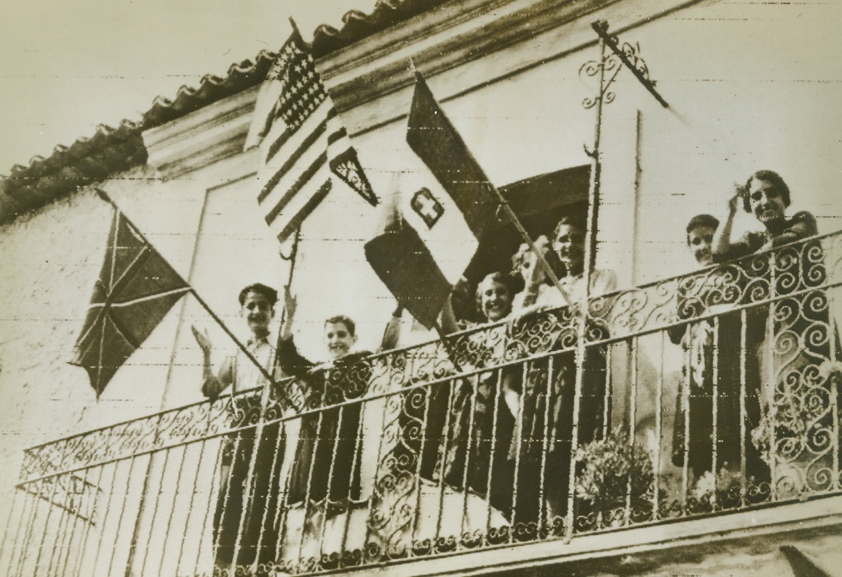 Flags out For The Allies, 9/16/1943. The Stars and stripes, a homemade Union Jack, and an Italian flag (hung upside down), are hung from this balcony in Staletti, Italy, in the Salerno area, as Canadian troops under Lt. Gen. Mark W. Clark enter the town. Today, Clark’s forces are advancing against stubborn German resistance, after eight days of the bloodiest fighting in the Mediterranean Campaign this photo by the Canadian Army, was flashed to New York by Radio today. 9/16/43 Credit Line (OWI Radiophoto ACME);