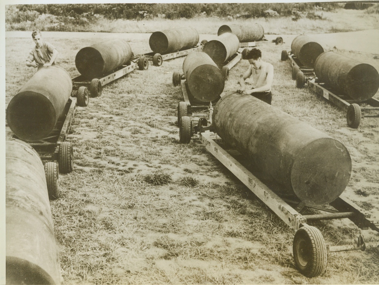 Oversize Eggs, 9/20/1943. SOMEWHERE IN ENGLAND -- When these "eggs" fall in enemy territory, they really do a job. Each of them tipping the scales at 4000 pounds, they are carried over Axis Europe by Lancaster bombers of the RAF. Here, workers check the oversize bombs before loading them onto Lancasters. Credit: (ACME);