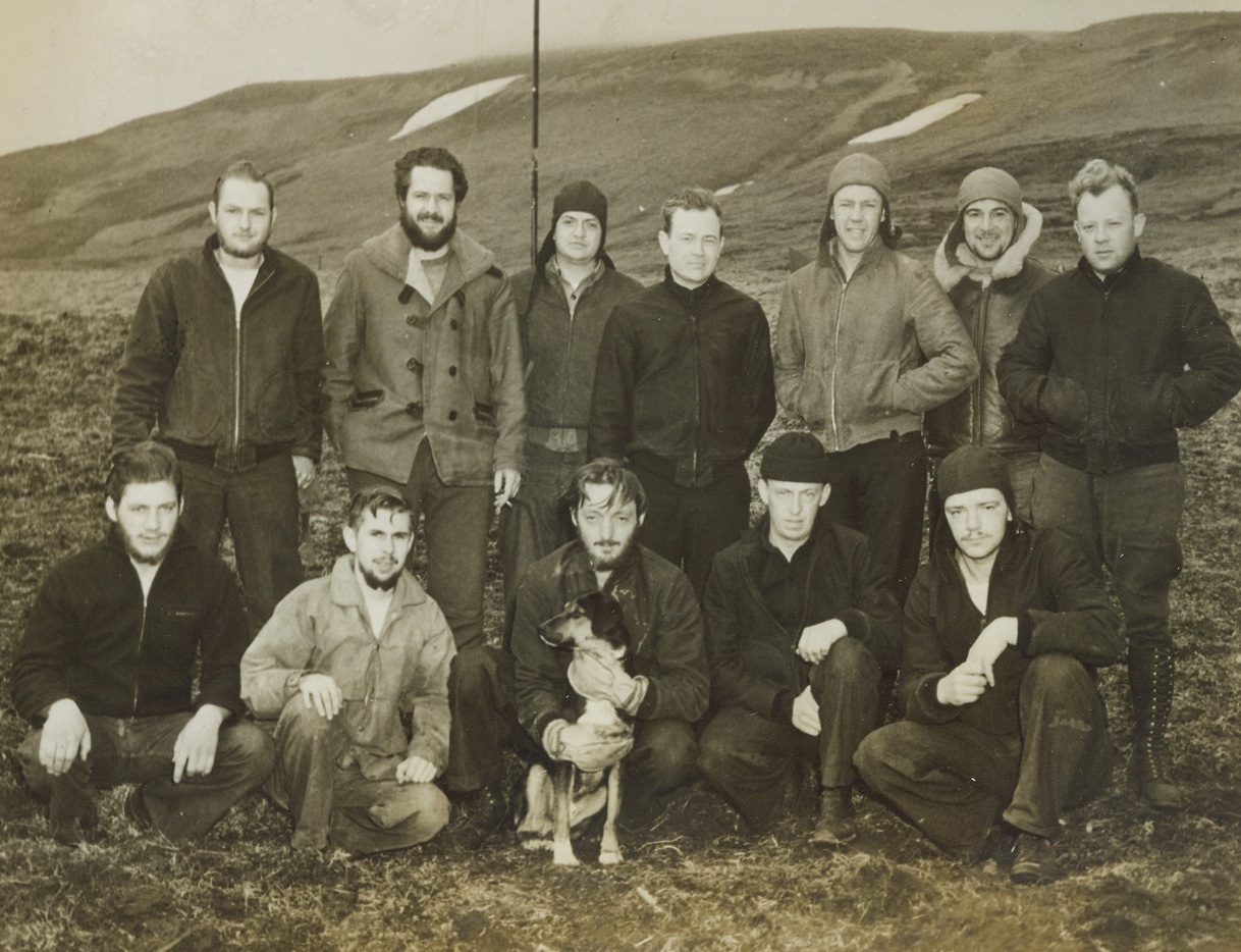 Ten of These U.S. Navy Men Are Jap Prisoners, 9/22/1943. In this photo, released today in Washington, twelve men of a U.S. Navy weather and radio station unit are shown in Kiska, where they were stationed before the Japs took the island. When U.S. forces recently recaptured Kiska, only the dog mascot was found. Two of the men in the picture were not on the island when it was captured by the Japs—the other ten are believed to be Jap prisoners. Left to right, front row: ship’s cook John C. McCandless, of Oakmont, PA.; radioman Robert Christensen, Bremerton, Wash.; aerographer’s mate Walter Monroe Winfrey, Cliffside Park, N.J.; seaman Gilbert F. Palmer, Evansville, Ind.; and Wilfred Ivan Gaffey, Coquille, Oregon. In the back row, left to right: aerographer’s mate James Leroy Turner, Seattle, Wash.; chief pharmacist’s mate Rolland L. Coffield, of Seattle, Wash.; aerographer’s mate William Charles House, Esconbito, Calif.; Lt. Mulla, (not captured); gunner’s mate LeThayer L. Eckles, Osborne, Kansas; photographer’s mate Lou Yaconelli, (not captured), North Hollywood, Calif.; radioman Madison L. Courtenay, Jr., of Riverhead, L.I., N.Y. (Passed by censors.) Credit: ACME;
