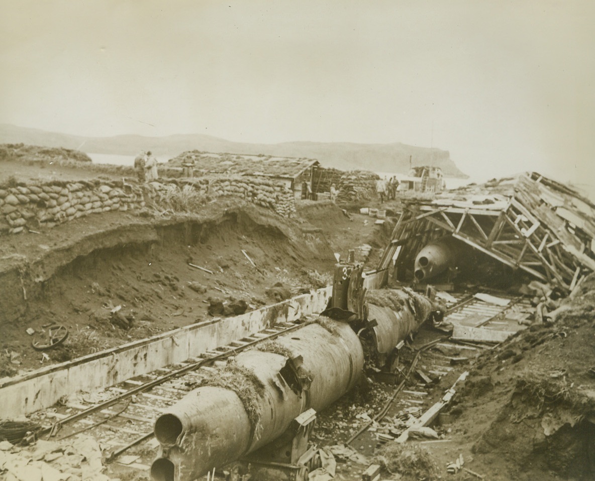 Scuttled Subs, 9/4/1943. Kiska – Evidently scuttled by their Jap owners as they fled Kiska, these wrecked.  Miniature subs were found by the allies when our troops took possession of the island.  This demolished submarine shed was about a mile from the former Japanese camp. Credit line—WP—(ACME);