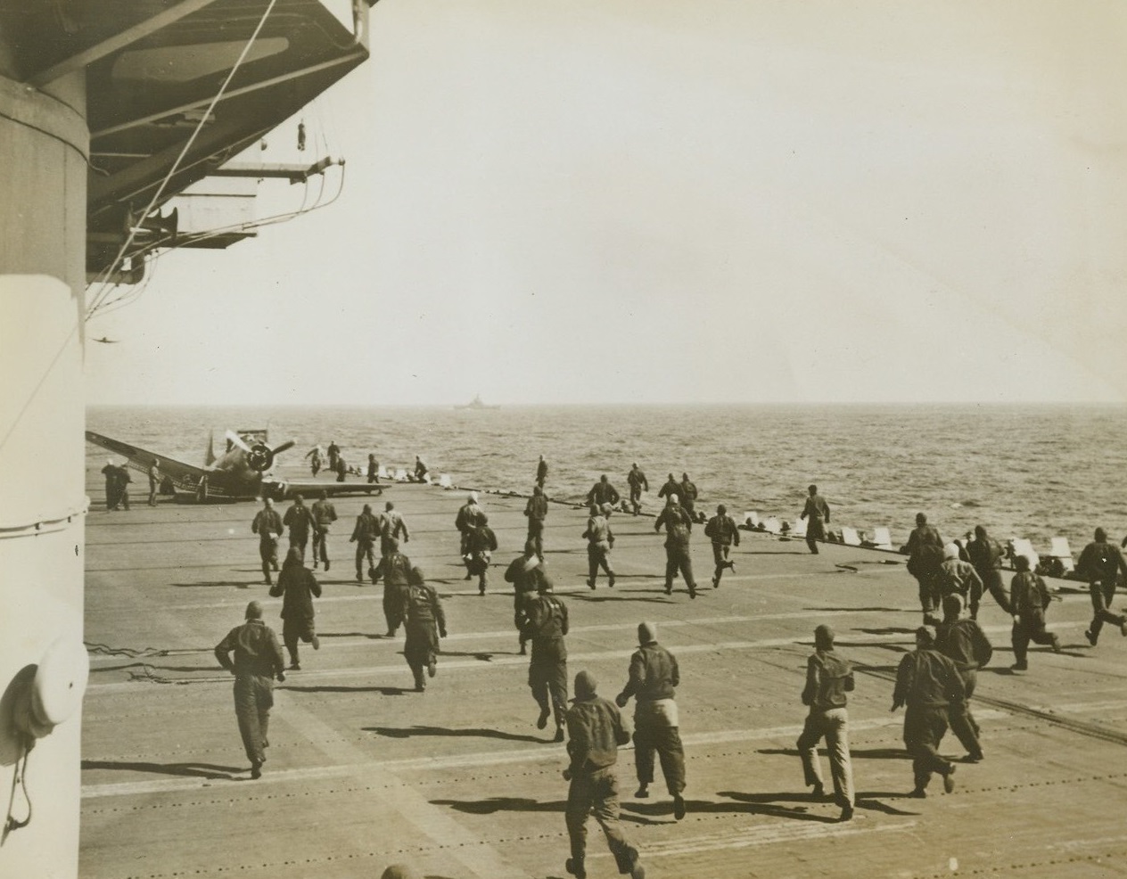 “Hot Squat”, 9/29/1943. Somewhere at sea – Crewmen of a U.S. Aircraft Carrier race to the assistance of the pilot of a Douglas Dauntless Dive Bomber which “pancaked” on the deck of the flattop. The pilot was not injured and the deck crew quickly ran the plane below, where it was repaired and put back into service. Credit: U.S. Navy photo from ACME;