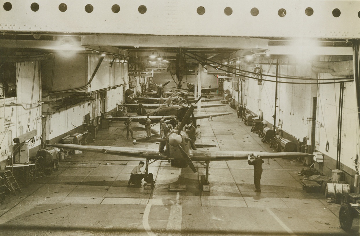 Flat-Top Celebrates Silver Jubilee, 9/20/1943. England – Mechanics work on one of the planes in the hanger of the H.M.S. Argus, British Aircraft Carrier. The flat-top recently completed 25 years of continuous service with the Royal Navy. Credit: ACME;