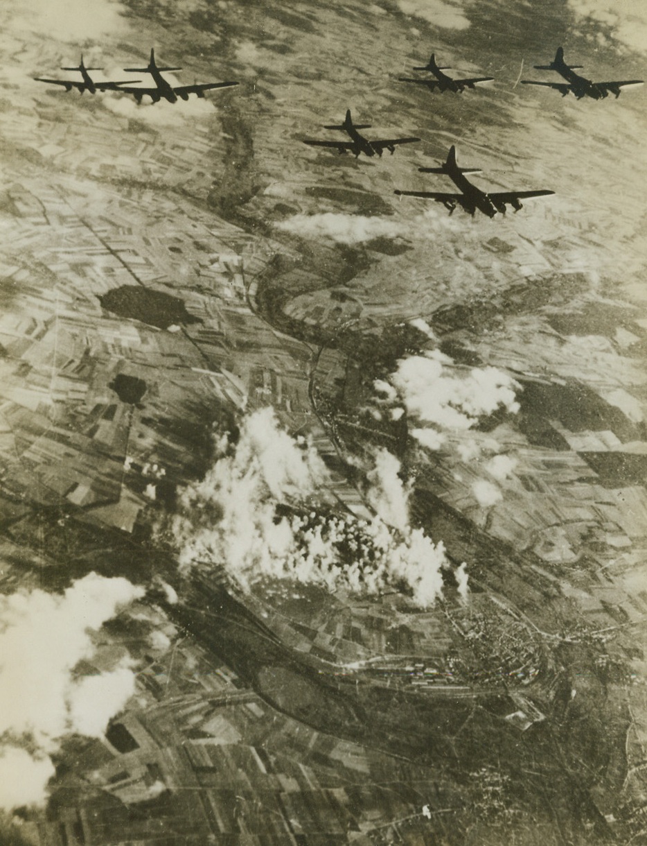 “Forts” Blast Nazi Airfield in France, 9/16/1943. In this photo, probably the most perfect view of bombing from the air yet produced, a formation of Flying Fortresses of the U.S. Army 8th Air Force, is shown over the Nazi-held airfield at Amiens-Glisy, France, during a raid on the important German fighter base last Aug. 31st. The boundaries of the base are clearly marked by columns of smoke from exploding bombs dropped by the American “Forts”. Allied air forces based in Britain, are concentrating heavily on the invasion coast and on aircraft factories and airfields in France, in recent raids. This may by the “softening-up” prelude to invasion. (Passed by Censors) Credit: ACME;