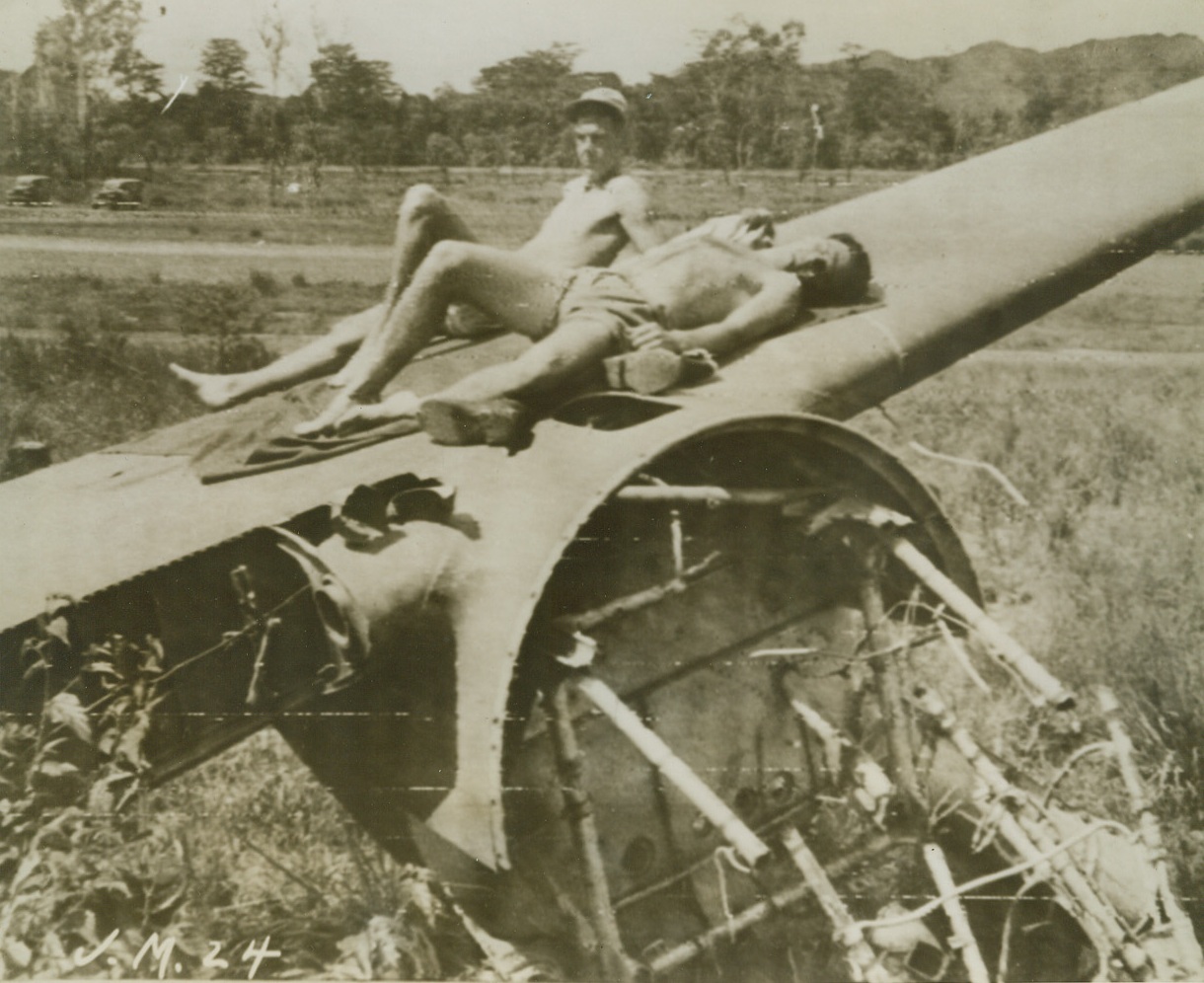 New Guinea Sundeck, 10/19/1943.NEW GUINEA – Between air attacks on Jap bases in the Southwest Pacific area, American Air Force Officers catch up on their sunbathing, stretched out on a crashed bomber on the edge of the jungle.  Left is 1st LT. William Fairbanks, of Glendale, California; Right Capt. Alex Guerry of Sewanee, Tenn.Credit  (ACME Photo by Frank Prist for the War Picture Pool Via ARMY RADIOTELEPHOTO.);